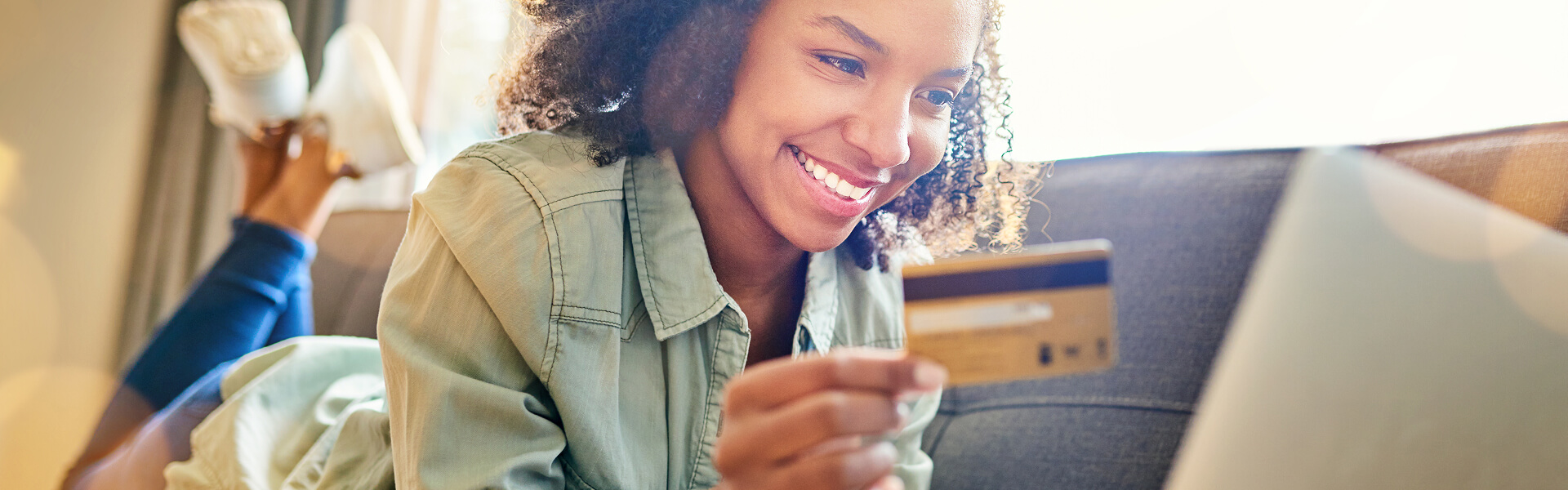 Smiling woman paying a dental bill online with a credit card at home, Lake Five Dentistry in Colgate WI.